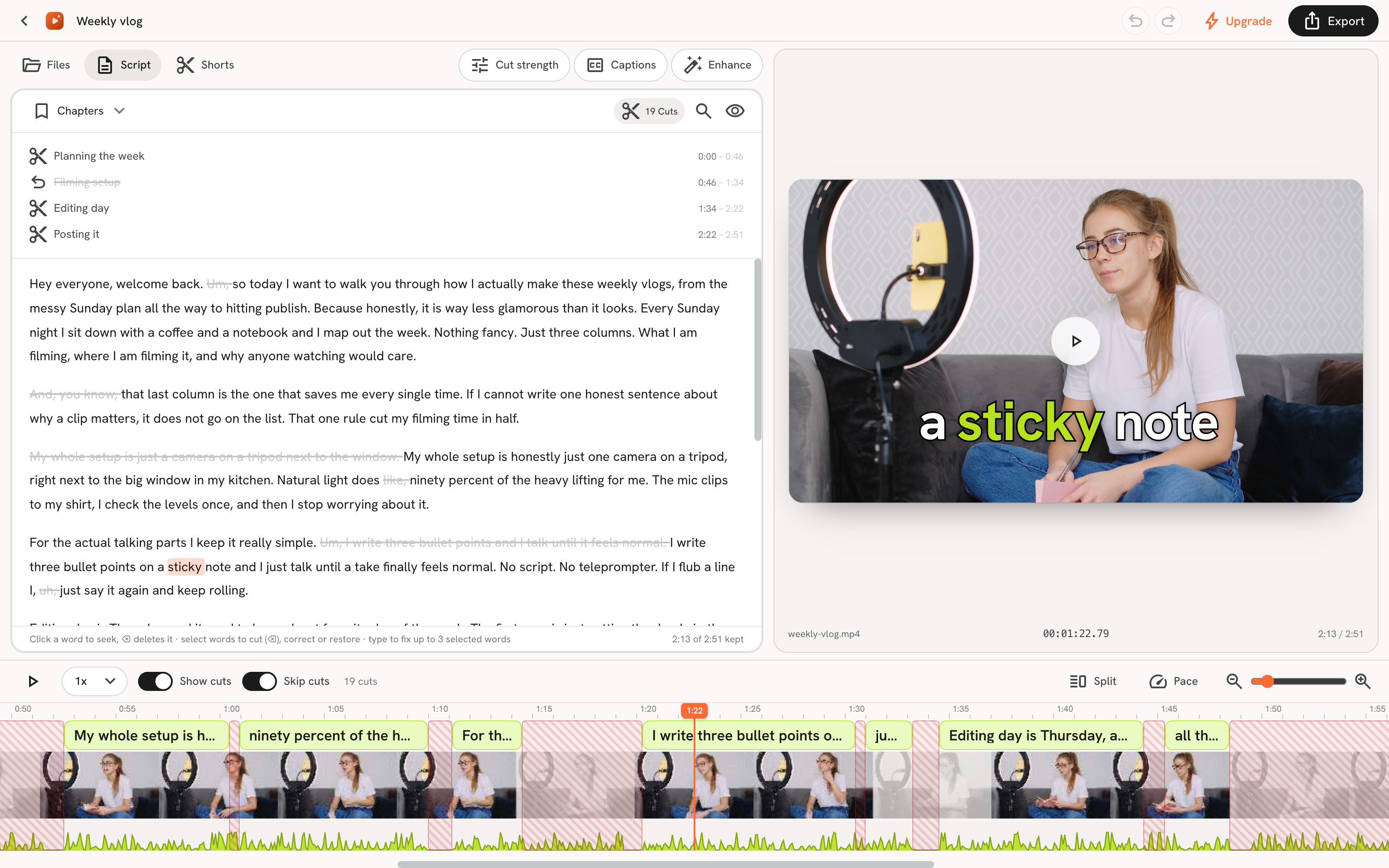 The editor with the transcript panel open, filler words and silences flagged with strikethroughs